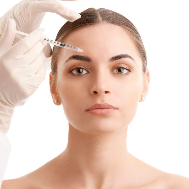 Woman at plastic surgery. Portrait of an attractive young woman receiving botox treatment. Isolated on white background